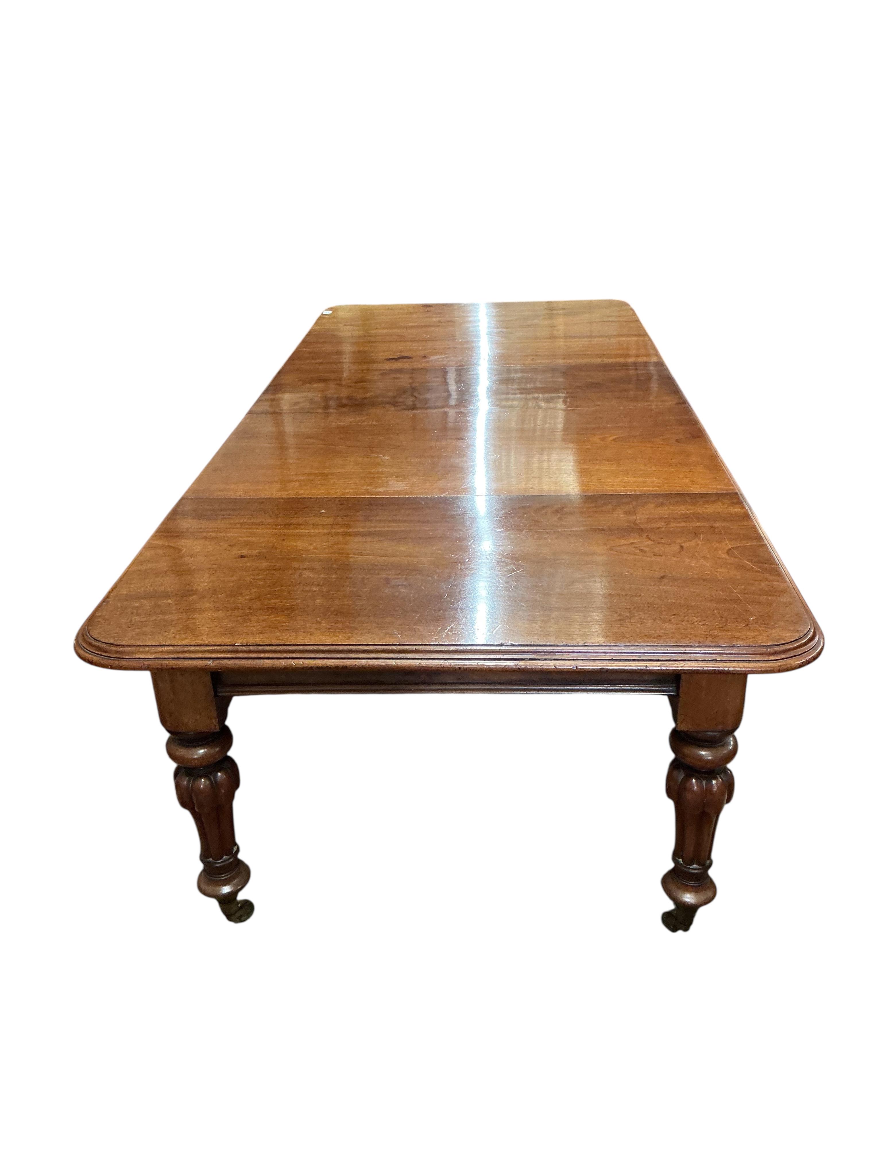 A Victorian mahogany extending dining table, width 285cm extended, three spare leaves